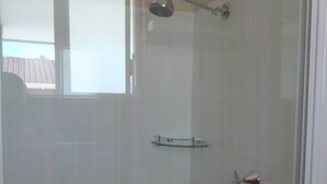 Een douche met glazen wanden, een handdouche en een extra douchestraal.