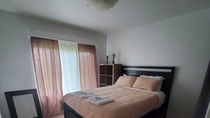 Una camera da letto con un letto, un comodino, un armadio e una lampada a sospensione.