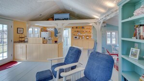 A cozy interior with a kitchen area, a dining table, and a bookshelf. - Cozy 'Fiddler's Rest:' Cabin: 11 Miles to Skiing! (Vernon)
