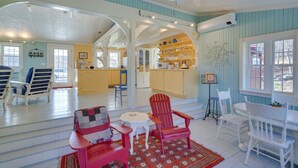 A spacious living room with a high ceiling, a kitchen area, and a dining area with red and white Adirondack chairs. - Cozy 'Fiddler's Rest:' Cabin: 11 Miles to Skiing! (Vernon)