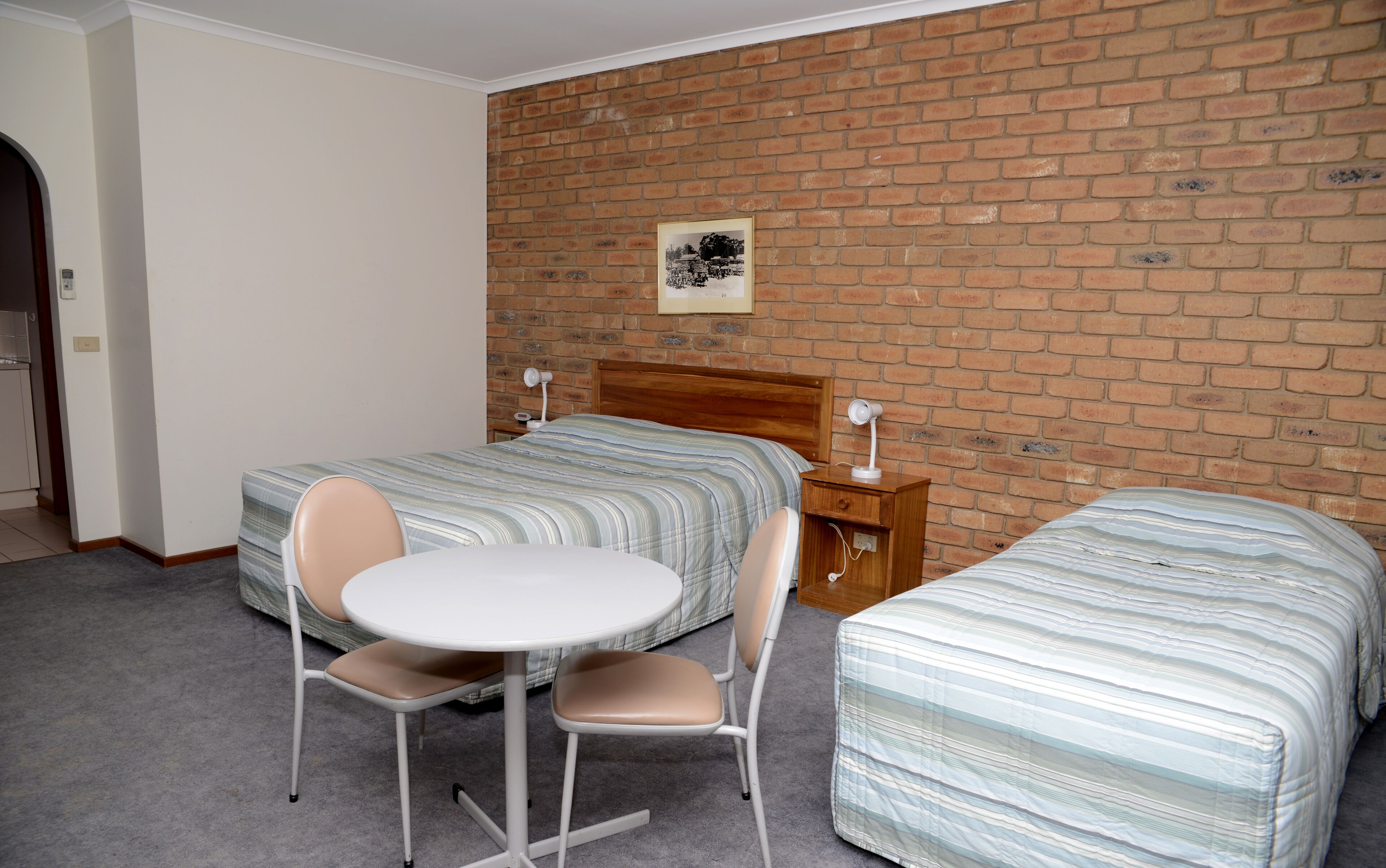 Une chambre d’hôtel avec deux lits, une petite table et des chaises.