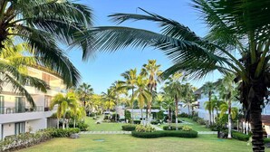 A resort with a well-maintained lawn, palm trees, and modern buildings. - Apartment for 5 with Balcony and Jacuzzi Oasis (Las Terrenas)