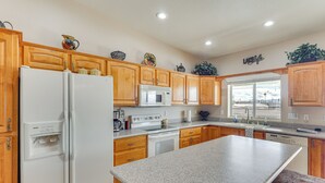 Una cocina con armarios de madera, un refrigerador blanco, un microondas y una estufa.