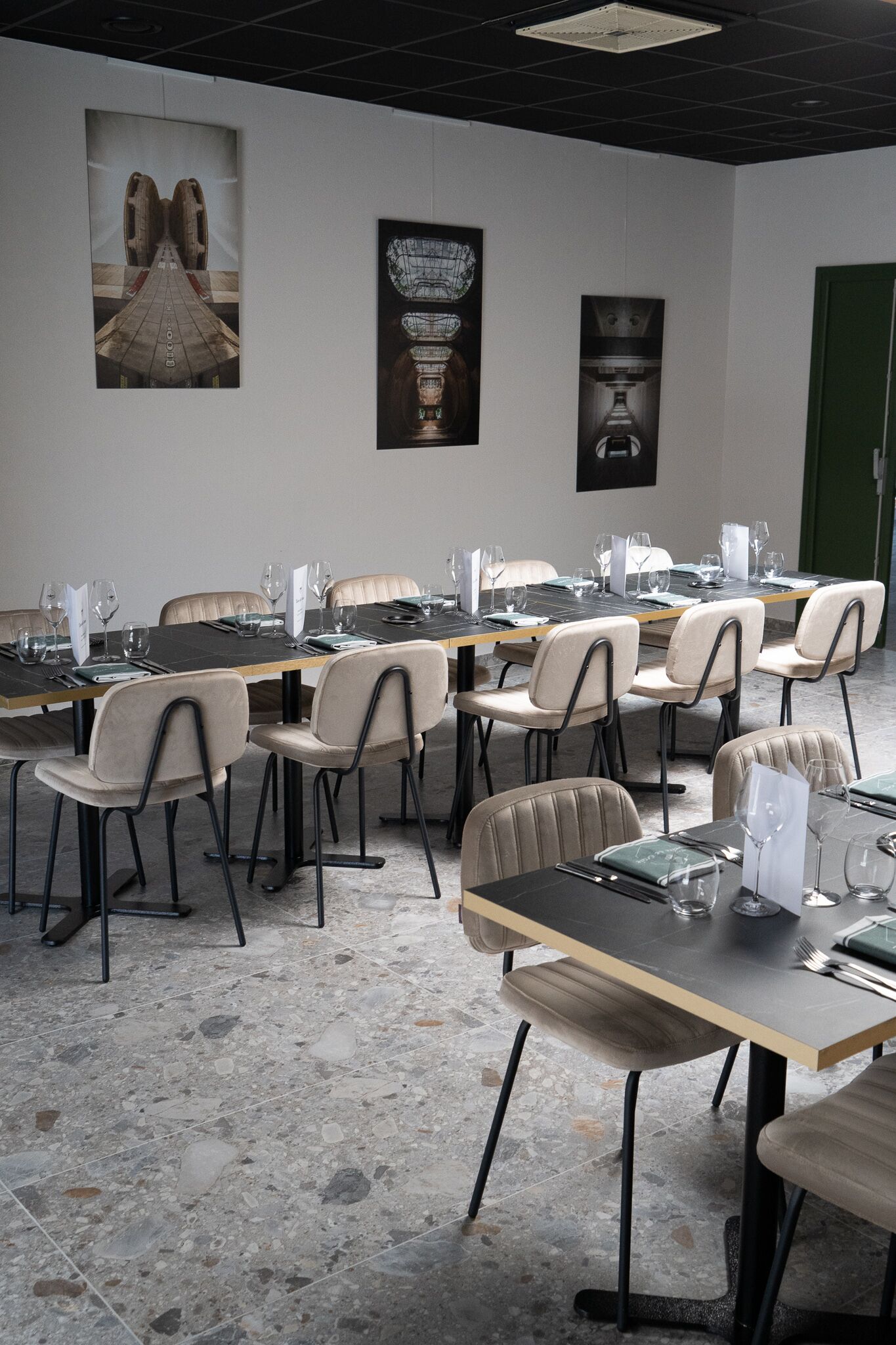 A conference room with a long table, multiple chairs, and framed artwork on the walls.
