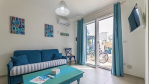 Una sala de estar moderna con un sofá, una mesa de centro y un televisor montado en la pared.