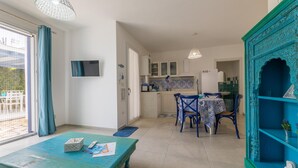Una cocina moderna con armarios blancos, una mesa comedor azul y sillas.