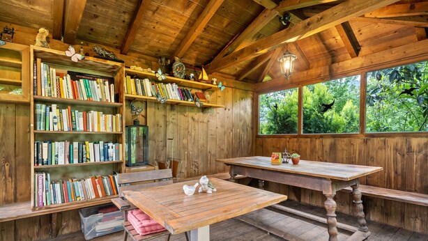 A wooden interior with bookshelves, a table, and a bench. - Apartment 'Annabelle' with Shared Garden, Wi-Fi, and Optional Private Pool Use (Lana)