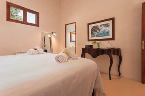 Une chambre d’hôtel avec un lit, un miroir, un tableau encadré et une petite table.