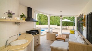 Una cucina con lavello, fornelli e vista sulla piscina.