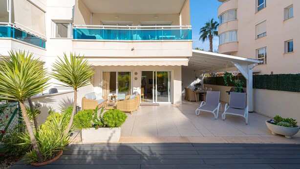 Un appartement moderne doté d’un balcon, d’un espace salon extérieur et de plantes en pot.