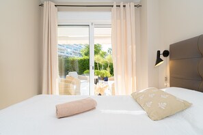 Een hotelkamer met een bed, uitzicht op de omgeving en een raam met gordijnen.