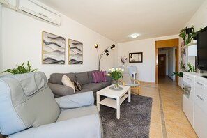 Una sala de estar con un sofá, una mesa de centro y un televisor.