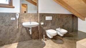 Un bagno con lavandino, WC, bidet e specchio.