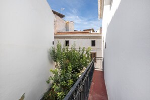 A narrow alleyway with white walls, a red-tiled roof, and a metal railing. - Holiday Home Casa Linda with Mountain View, Wi-Fi, A/C, Balcony & Terrace (Guaro)