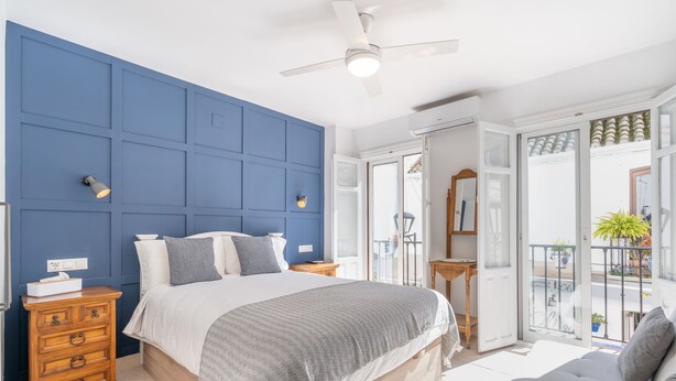 A bedroom with a large bed, a dresser, a ceiling fan, and a balcony with a view. - Las Brisas Estepona (Estepona)