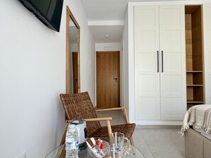 A room with a bed, a large wardrobe, a chair, a table with a kettle, a bottle, and glasses. - Las Brisas Estepona (Estepona)