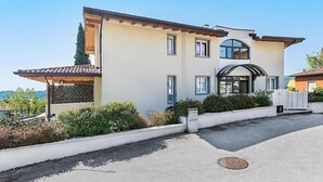 A two-story building with a flat roof, a large arched entrance, and a covered porch. - Apartment 'Rocchetta' with Lake View, Wi-Fi and Air Conditioning (Salò)