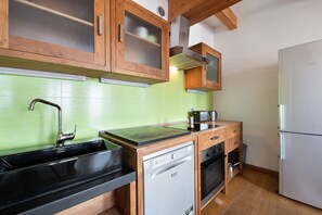 A kitchen with wooden cabinets, a dishwasher, an oven, and a refrigerator.