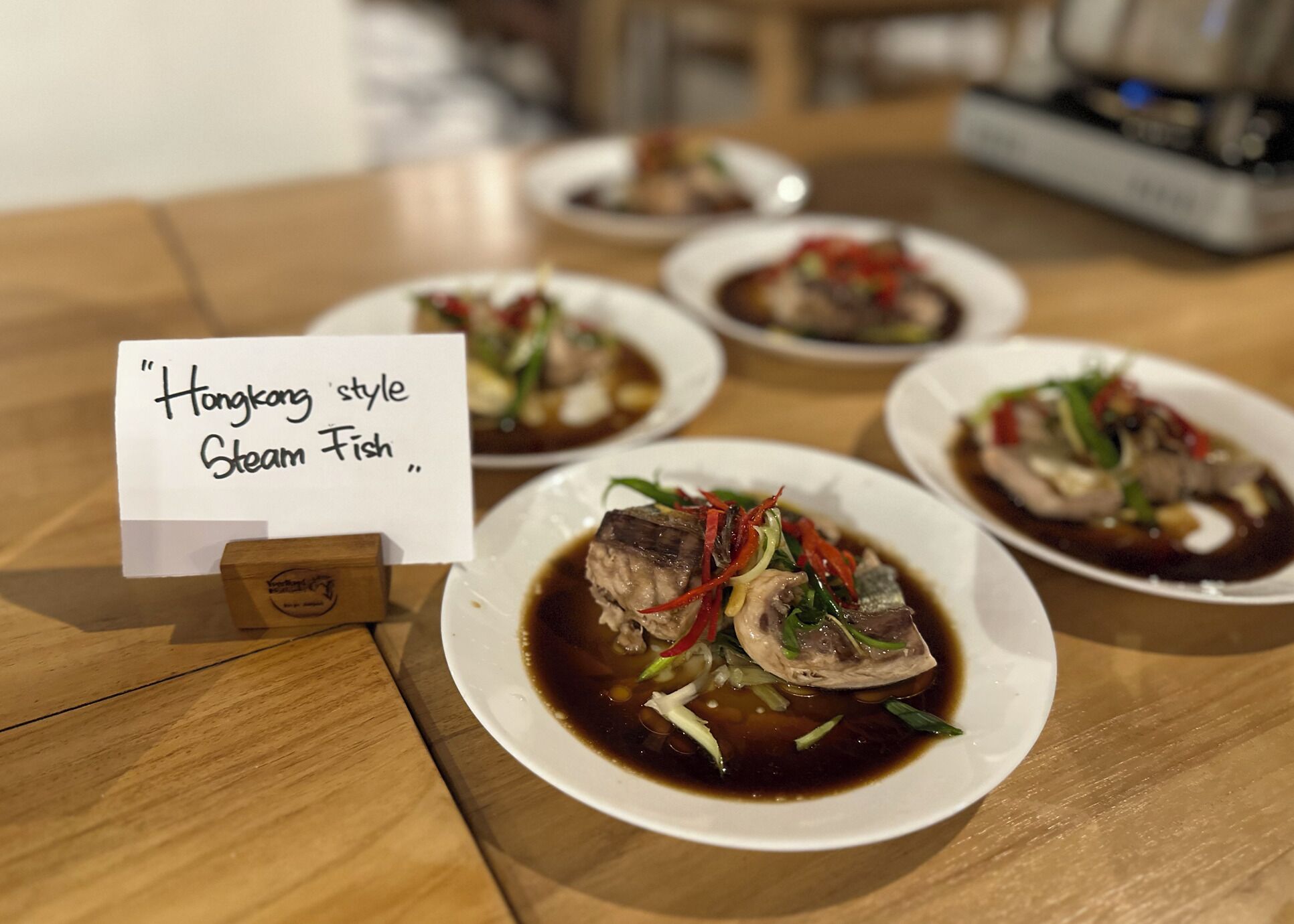 A table with dishes labeled "Hong Kong style Steam Fish."