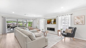 A modern living room with a sofa, armchair, and a fireplace. - D'VINE COTTAGE - THE VINTAGE HOLIDAY HOUSES (Rothbury)