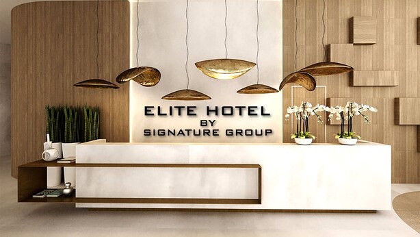 Un comptoir d’accueil avec une enseigne indiquant : « HÔTEL ELITE, un établissement du groupe SIGNATURE ».