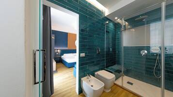 Ein modernes Badezimmer mit Duschkabine aus Glas, einem Bidet und einer Toilette.