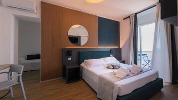 A modern hotel room with a bed, bedside table, and a chair.