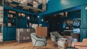 A modern interior with teal walls, wooden flooring, and contemporary furniture. - Taliammari (Cefalù)
