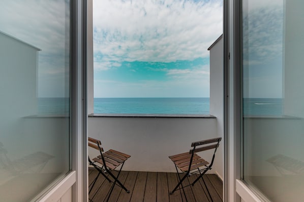 A balcony with two wooden chairs and a view of the sea. - Taliammari (Cefalù)