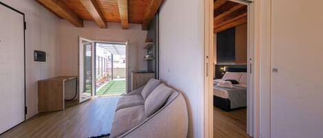 Un salon moderne avec un grand fauteuil poire, un plancher en bois et une vue sur un espace extérieur.
