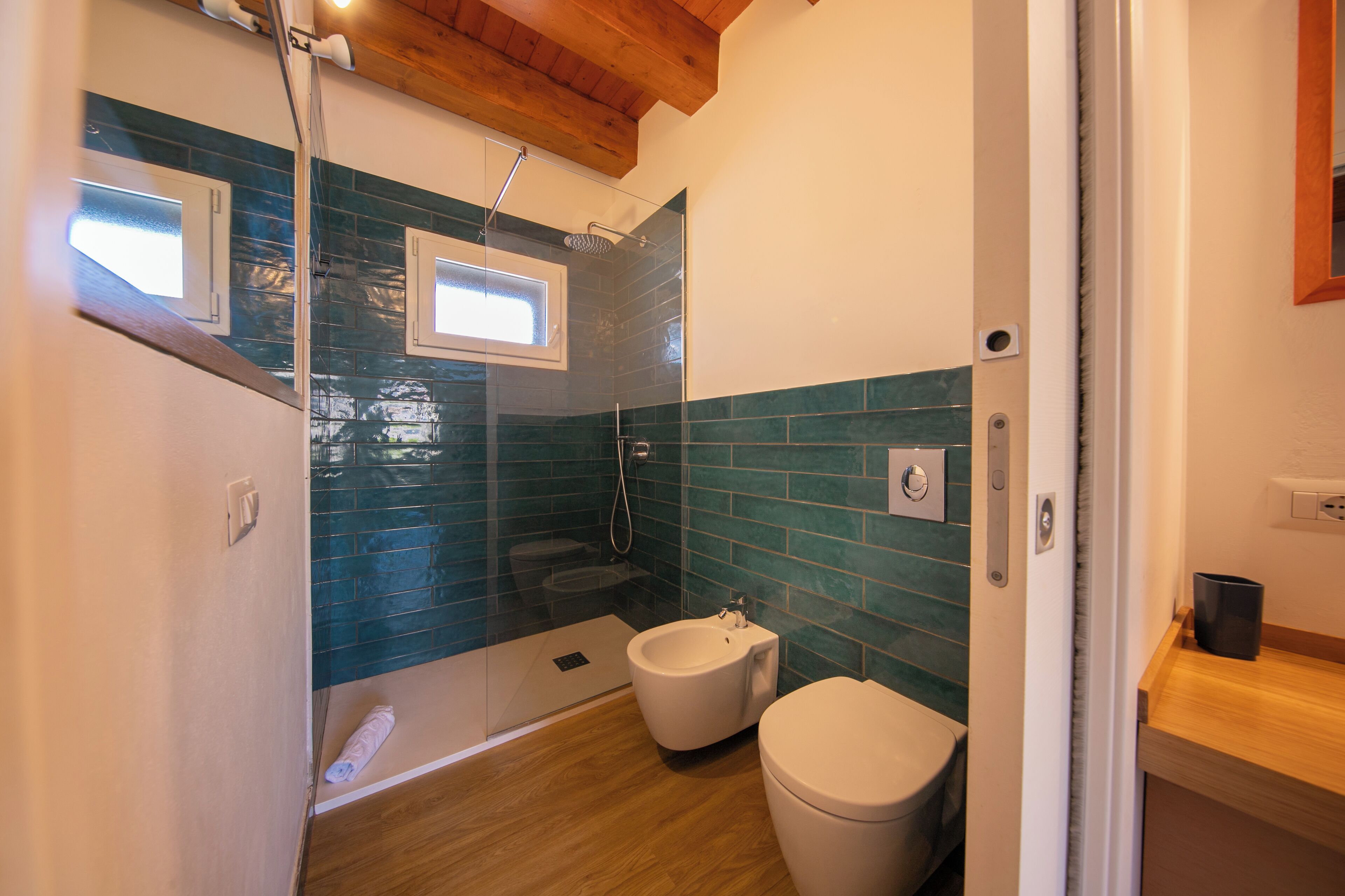 Ein modernes Badezimmer mit einer Duschkabine, einem Bidet und einer Toilette.