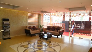 A lobby with two sofas, a coffee table, and a reception desk with brochures. - Raaj Bhaavan Clarks Inn Chennai (Chennai)