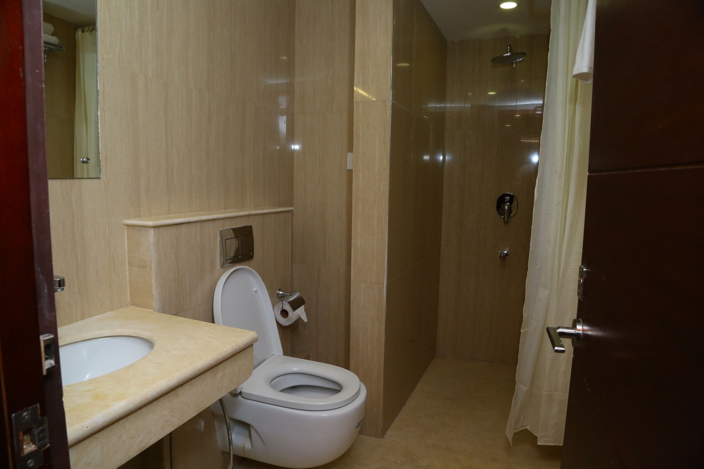 A bathroom with a toilet, sink, and shower area.