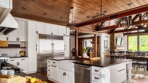 Een moderne keuken met witte kasten, roestvrijstalen apparatuur en een groot eiland.