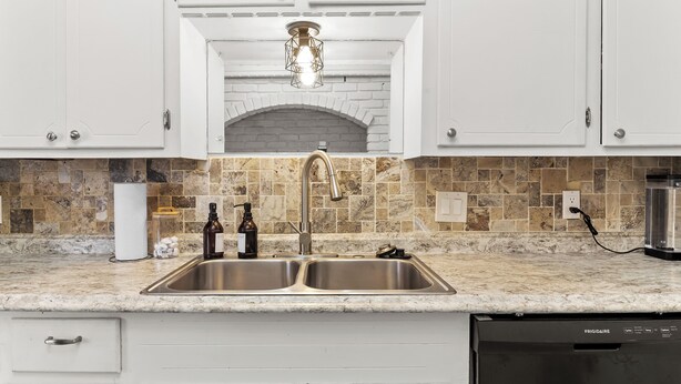 A kitchen with white cabinets, a double sink, and a built-in dishwasher. - Beautiful home w/easy access to anywhere in Tulsa! (Tulsa)