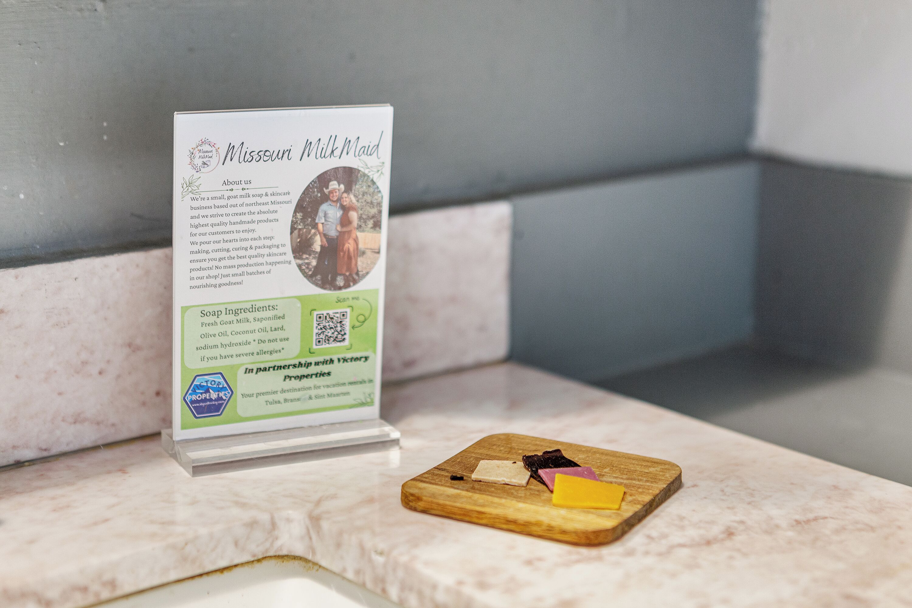 A sign for Missouri Milk Maid soap with a wooden cutting board with cheese and meat.