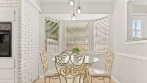 A dining area with a round glass table, four chairs, and a chandelier. - Beautiful home w/easy access to anywhere in Tulsa! (Tulsa)