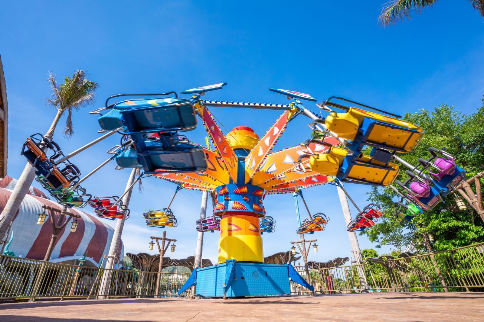 A colorful amusement ride with multiple seats attached to a central rotating structure.