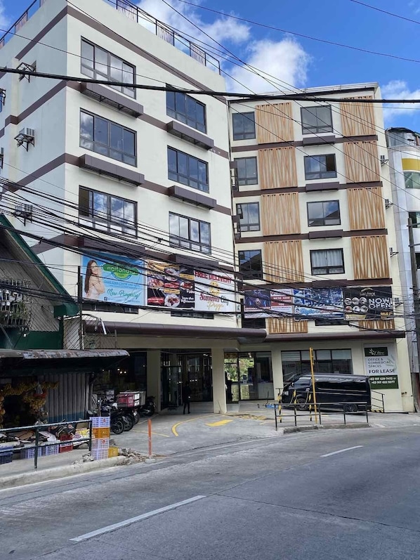 Un immeuble à plusieurs étages dont le rez-de-chaussée est occupé par des commerces, notamment un restaurant, et qui propose également des espaces de bureaux à louer.