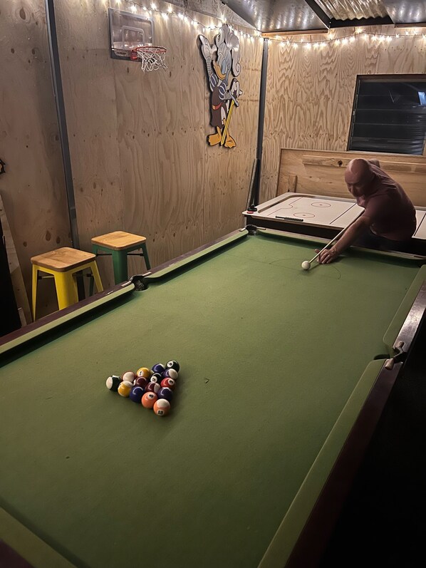 A pool table with balls, a wooden wall, a small stool, and a decorative wall piece. - Lake & Mountain views with deck and games room for all to enjoy (linen provided) (Goughs Bay)