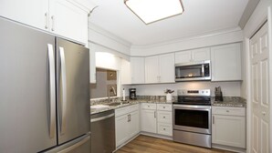 A modern kitchen with white cabinets, stainless steel appliances, and a granite countertop. - 19 F Pinehurst Manor: 1  BR, 1  BA Condominium in Pinehurst, Sleeps 3 (Pinehurst)