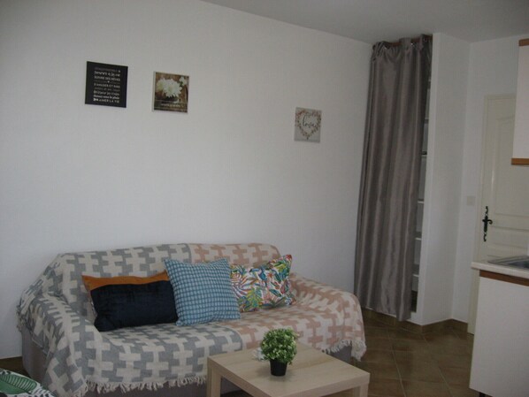 Ein Wohnzimmer mit einer Couch, einem Couchtisch und einer Tür rechts.