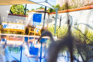 A swimming pool with a blue door, a white fence, and a mural of a swan. - Rhodium Hotel (Cesme)