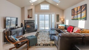 A spacious living room with a fireplace, a television, and a large window overlooking a scenic view.