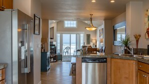 A modern kitchen with stainless steel appliances, a granite countertop, and a view to the dining area.