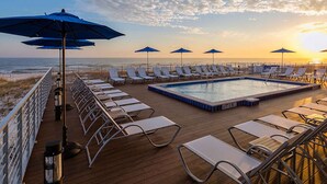 A poolside area with lounge chairs and umbrellas, overlooking the ocean. - Deja Blue | Dazzling Townhome, Great Amenities! (Pensacola)