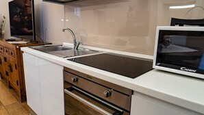 Una cocina moderna con microondas integrado, un lavamanos y una estufa.