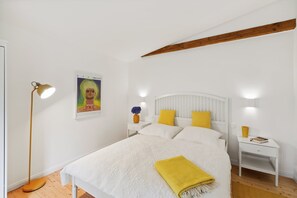 A bedroom with a bed, bedside tables, a floor lamp, and a poster on the wall. - My deer House - Green retreat for the whole family (Wörthsee)