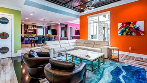 A modern living room with a sectional sofa, leather armchairs, a coffee table, and a large window. - Last Minute Disney Getaway! Private Pool, Hot Tub & Game Room. Book Now! #6266 (Orlando)