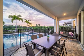 Une terrasse extérieure moderne dotée d’une piscine, d’un espace salon et offrant une vue sur le paysage environnant.